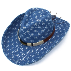 Détail du chapeau de cowboy en denim bleu avec paillettes argentées et décor de plumes dorées
