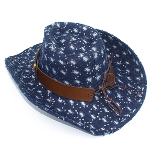 Close-up of distressed denim cowboy hat with sequins and brown leather band detail