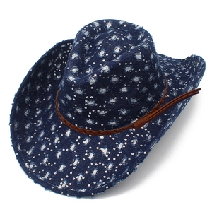 Close-up of blue denim cowboy hat with distressed holes, sequins and brown leather band
