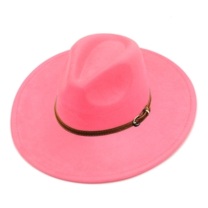 Detail of hot pink wide brim fedora featuring brown leather band with golden buckle