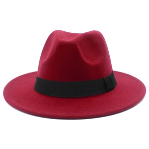 Detailed close-up of a red wool fedora hat featuring a classic black decorative ribbon band