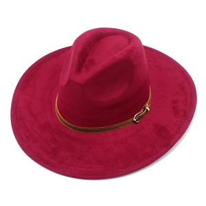 Detail of burgundy wide-brim suede fedora featuring a brown leather band and gold buckle