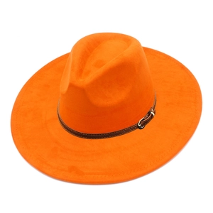 Macro shot of bright orange suede fedora crown with brown leather belt and gold metal buckle
