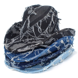 Detailed stack of denim cowboy hats showing frayed tassel edges in black and blue tones