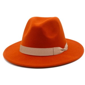 Detailed view of orange wool fedora hat with a light brown grosgrain ribbon and bow accent