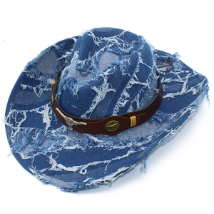 Détail de la texture denim vieilli avec emblème tête de taureau en métal sur ceinture