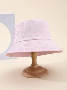 Close-up of pink lace bucket hat featuring delicate floral embroidery on wood stand