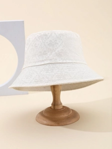 Close-up detail of white cotton lace bucket hat with intricate floral crochet texture