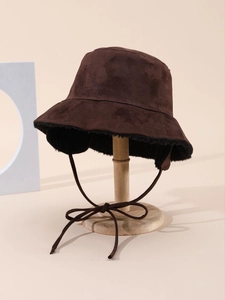 Close-up of brown faux suede bucket hat with warm black faux shearling lining and earflaps