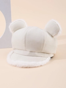 Detail of plush bear ears and soft faux fur trim on a cream white knit newsboy hat