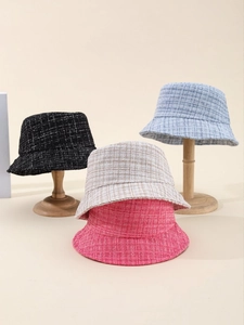 Detail view of plaid tweed bucket hats in black, blue, beige, and pink colors