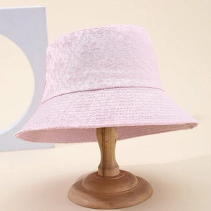 Pink lace floral bucket hat with 3D embroidery and wide brim on a wooden stand