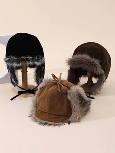 Dettaglio di cappelli invernali in pelle scamosciata nera, marrone e caramello con finta pelliccia
