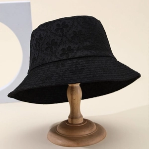 Women's black lace floral embroidery bucket hat displayed on a wooden stand