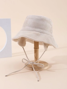 Close-up of beige suede bucket hat with warm white faux shearling lining and long ties