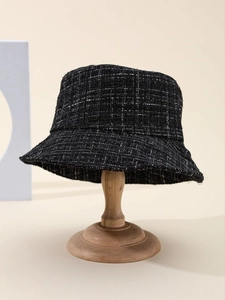 Detailed texture of black and white tweed fabric on an elegant bucket hat for women