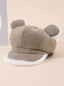 Detail of khaki plush newsboy hat with bear ears and soft white faux fur trim texture