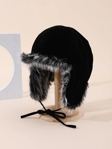 Dettaglio del cappello aviatore nero con fodera in ecopelliccia su un supporto di legno