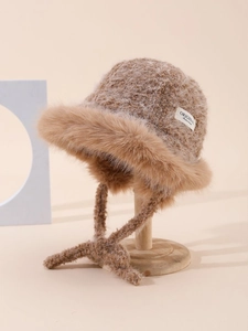 Close-up of camel knit bucket hat featuring faux fur trim and original logo label