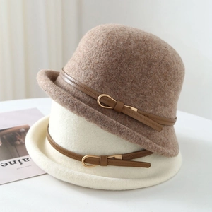Détail de chapeaux en feutre de laine avec bandes en cuir et boucles dorées
