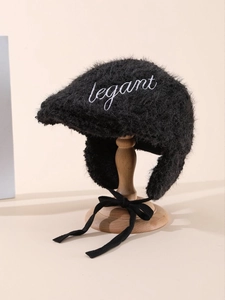 Detail of plush faux fur winter hat with elegant embroidery and side earflaps