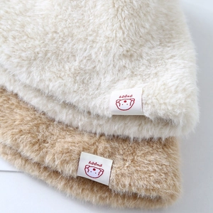 Soft plush bucket hats in cream and camel colors with cute cartoon patches on brim