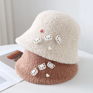Close-up of soft teddy fleece bucket hats in beige and brown with cute bear patches