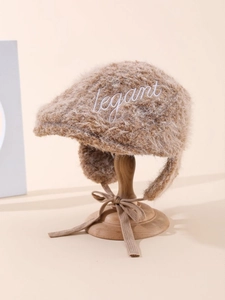 Detail of winter plush earflap hat with Elegant embroidery and chic side ties