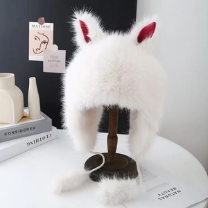 White plush trapper hat with cute bunny ears and pom-pom tassels on a wooden stand