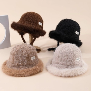 Winter plush bucket hats with fur trim and straps in four colors on minimalist stands