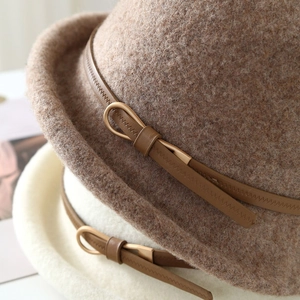 Détails de la texture du chapeau en feutre de laine avec sangle en cuir et boucle dorée