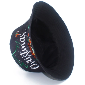 Vista detallada de un gorro de pescador negro con estampado de árboles y caramelos
