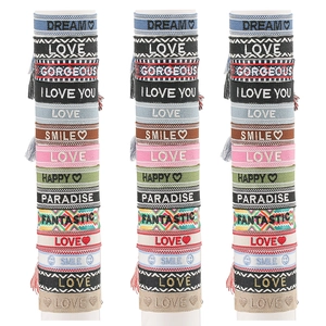 Detailed view of colorful woven bohemian embroidery bracelets with positive lettering and tassels