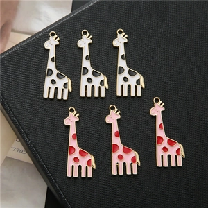 Macro-opname van gevlekte giraf-bedels in wit en roze voor DIY-sieraden maken