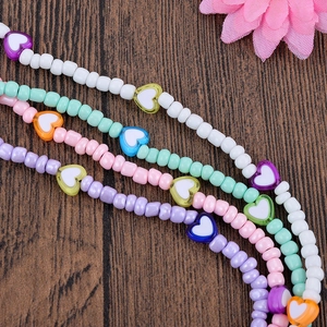 Handmade colorful heart beaded mobile phone lanyards with round beads on wood background