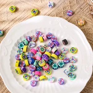 Perles fleurs en pâte polymère colorées 10mm pour bijoux DIY disposées dans un plat blanc
