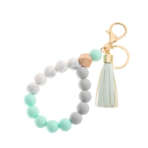 Detail view of silicone beads and wood hexagon bead with gold lobster clasp on keychain