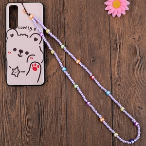 Detail of handmade colorful heart-shaped beads and purple seed beads on mobile phone strap