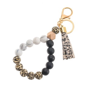 Detail of beaded keychain bracelet with leopard print silicone beads and a gold lobster clasp