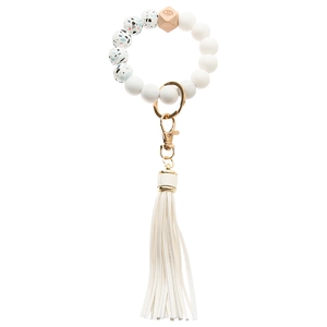 Detail of beaded keychain wristlet with white silicone beads, wood bead, and leather tassel