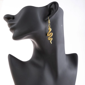 Long golden snake drop earrings with scale texture on black mannequin model
