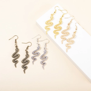 Long snake-shaped drop earrings in four metallic finishes shown on aesthetic display blocks