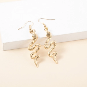 Detailed close-up of golden snake earrings showing intricate scales and curved design