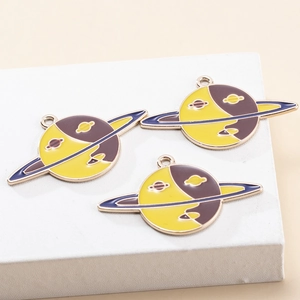 Detailed view of Saturn-shaped enamel charms in yellow and purple with gold plating