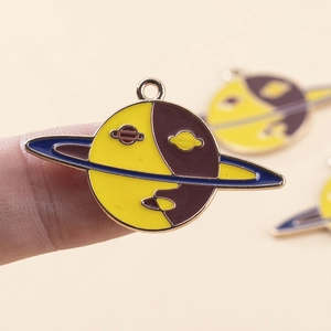 Macro shot of Saturn shaped enamel pendant charm with gold edges for DIY jewelry making