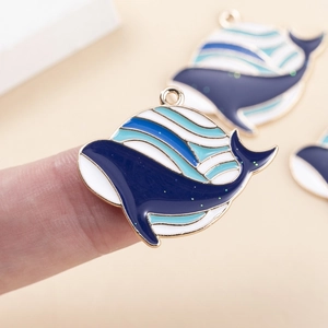 Detail of blue whale enamel pendant with gold alloy frame for DIY jewelry making