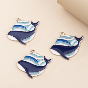 Detailed view of alloy whale charms with blue and white enamel dripping in gold finish