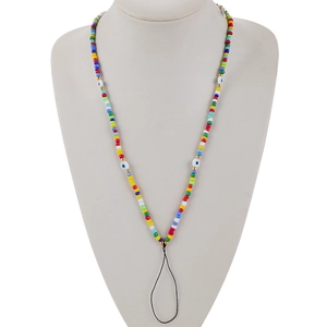 Detail of colorful beaded phone lanyard featuring evil eye beads on a white display