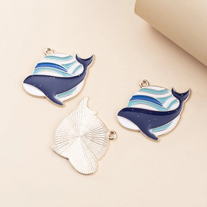 Detail view of whale-shaped alloy pendants with blue enamel finish for DIY jewelry