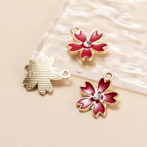 Macro shot of red cherry blossom alloy pendants with rhinestones for DIY jewelry making